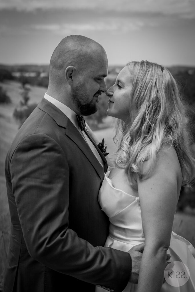 A wedding couple kissing outdoors in black and white