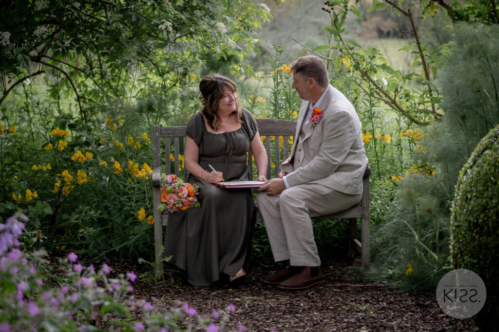 A couple signing the marriage register in a garden setting
