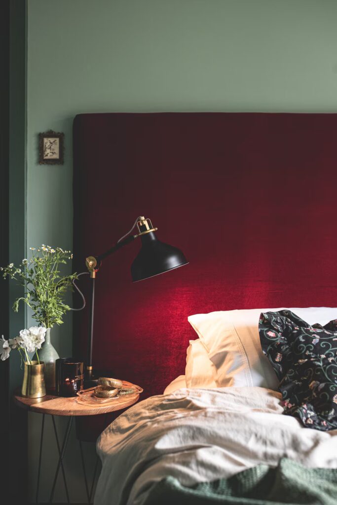 Bedroom with a red upholstered bedhead and a bedside lamp