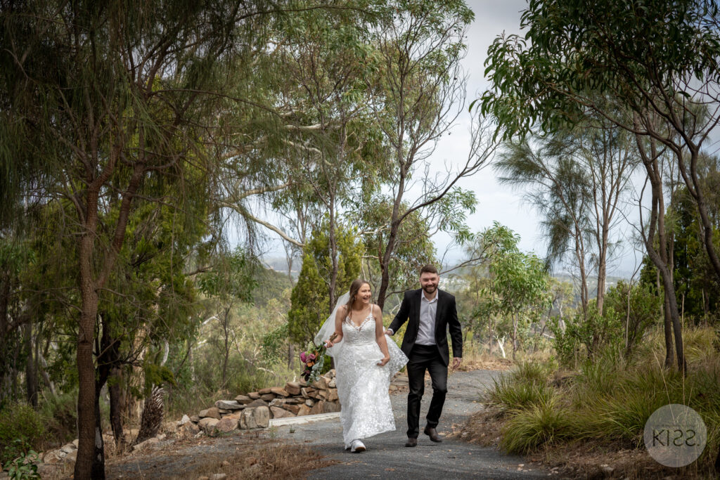 A wedding couple walking along a garden path