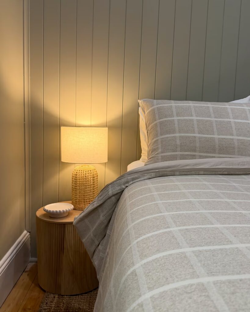 Cottage bedroom with a checked bedspread and bedside lamp