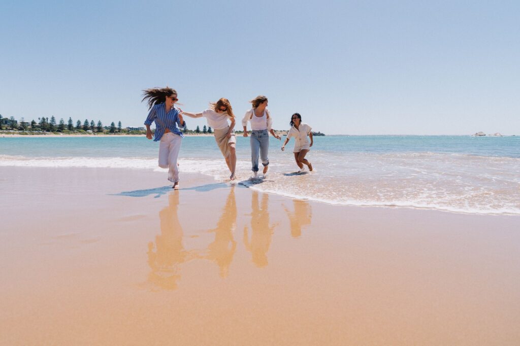Visitors running along the beach at Port Elliot.