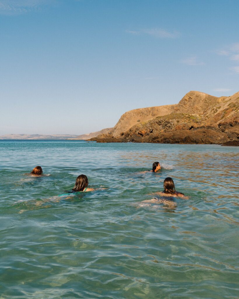 Swimmers in the bay below the cliffs at Second Valley.