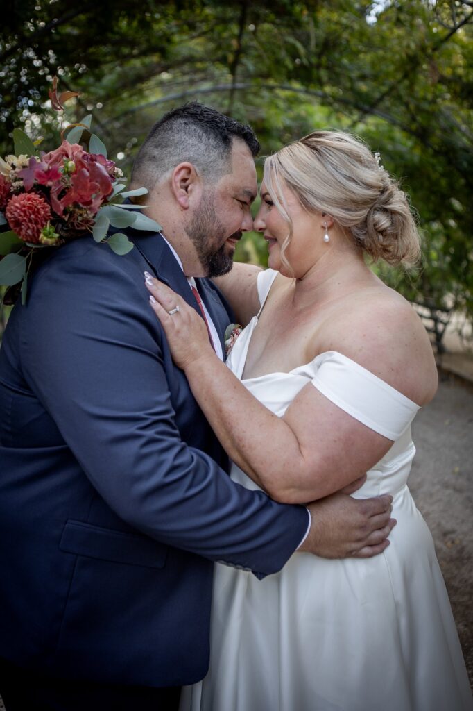 A newly married couple sharing a kiss at Adelaide Botanic Garden