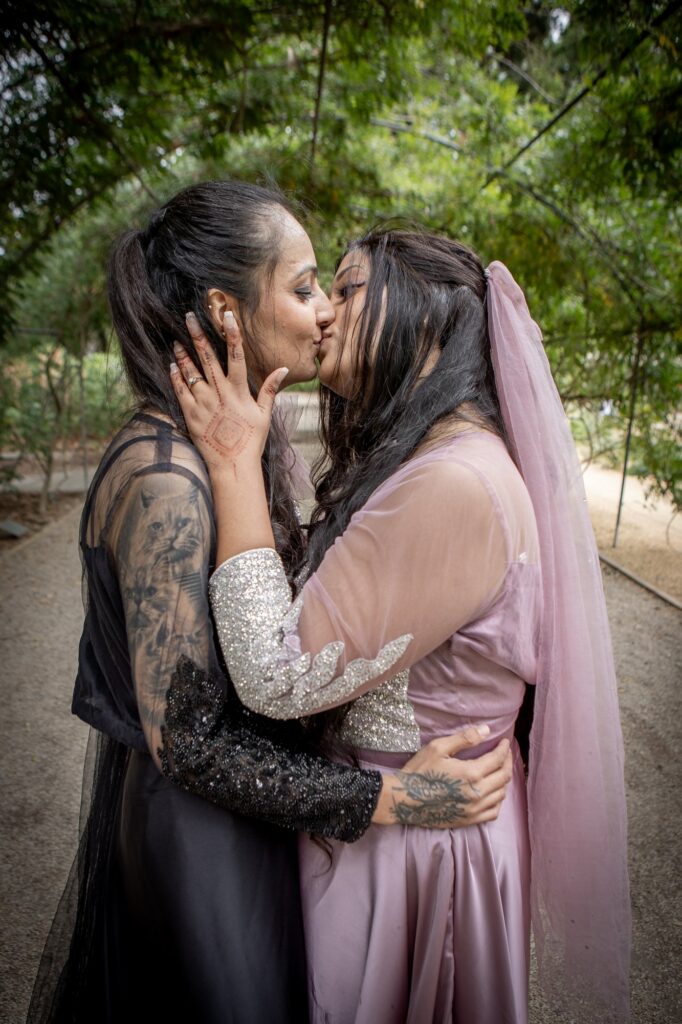 A couple sharing a kiss among garden greenery