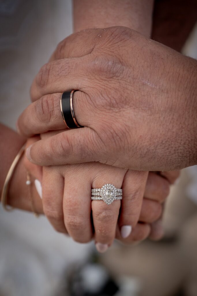 A close view of a couple's hands and wedding rings